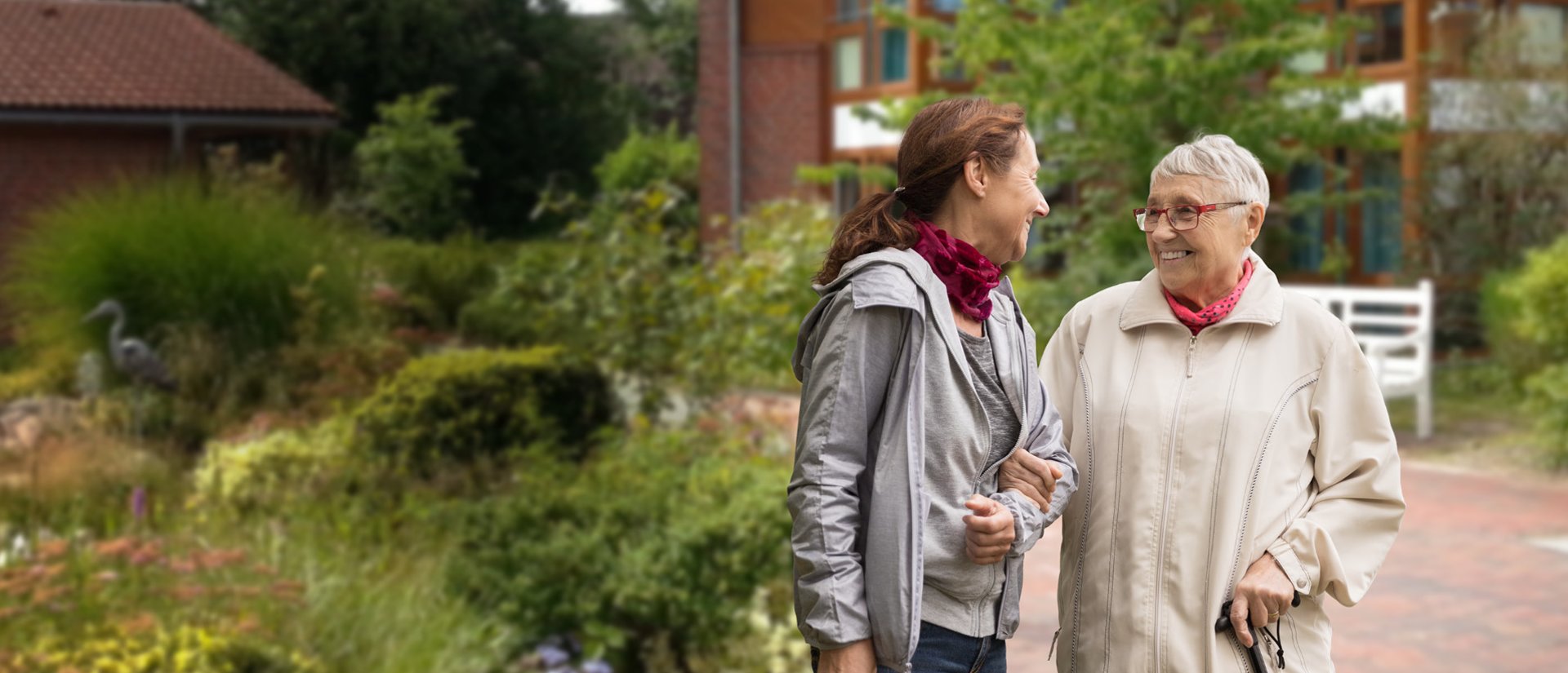 Tochter und Mutter gehen im schönen Garten des Lotte-Lemke-Hauses spazieren